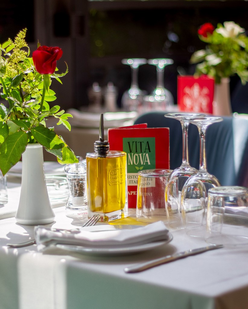 Table dressée, huile d'olive et carte Vita Nova